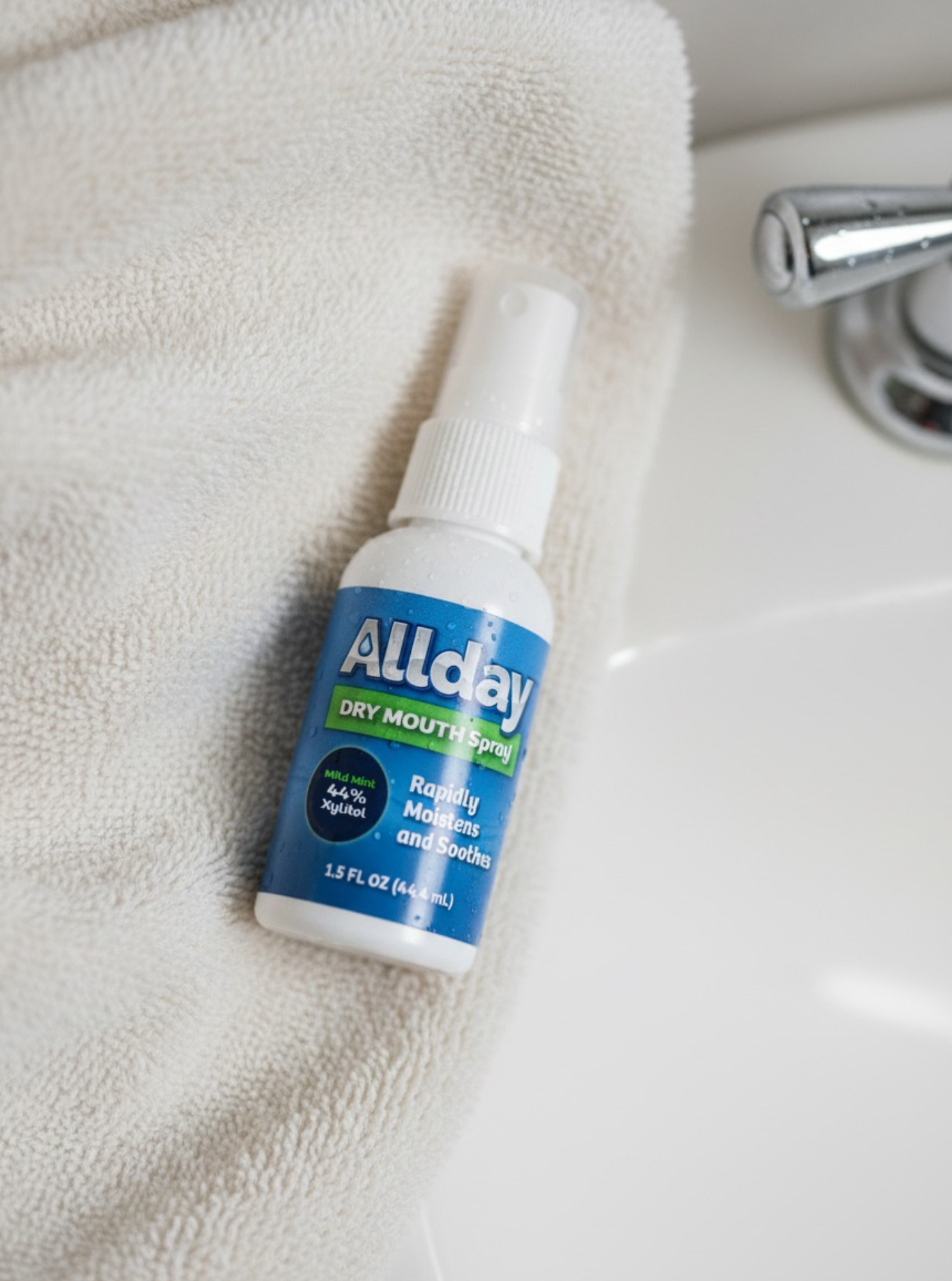 Allday Dry Mouth spray pictured on a table in the bathroom on top of a towel